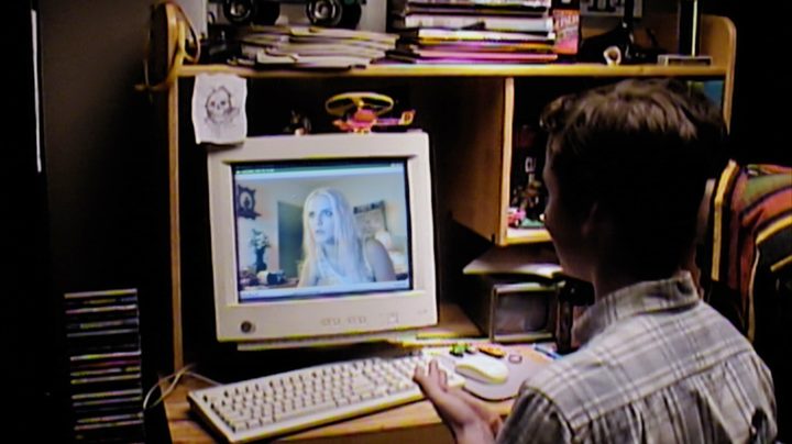 A male teenager sits at a computer in V/H/S/99.