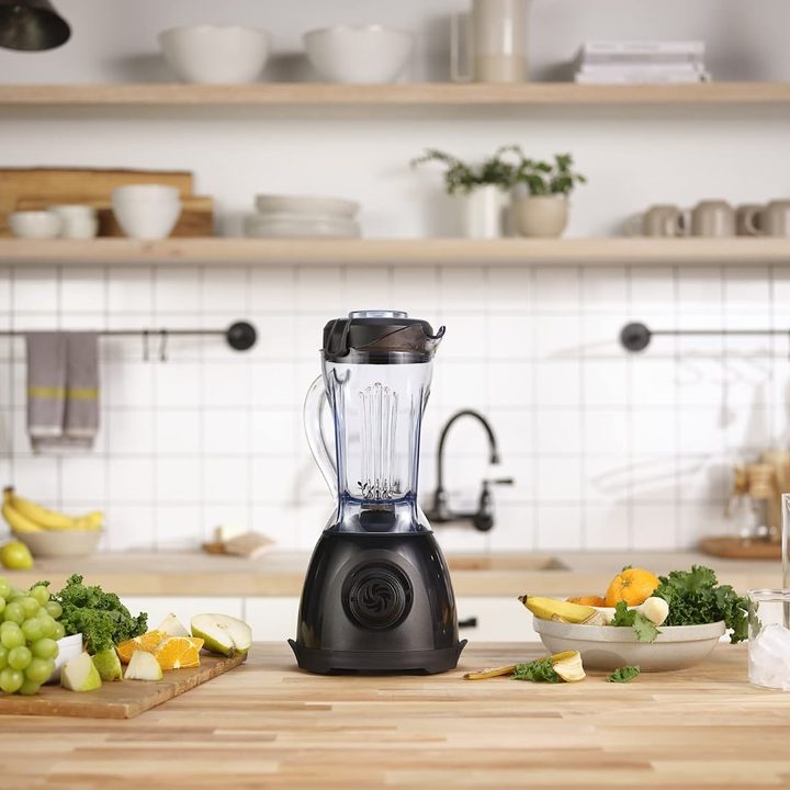 Vitamix One sits on kitchen counter next to fruits and vegetables.