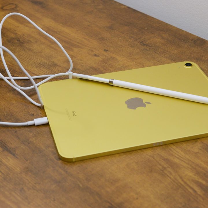 The iPad (2022) with an Apple Pencil plugged into it using a USB-C cable and adapter.