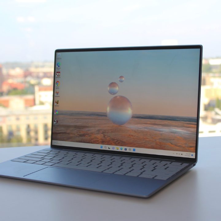 The Dell XPS 13, open on a table in front of a window.