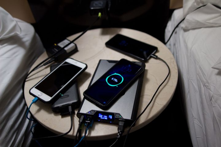 The Goal Zero Sherpa 100AC charging multiple devices on a bedside table.