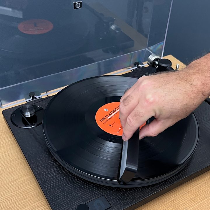 Placing the anti-static brush on the record at the seven o'clock position.