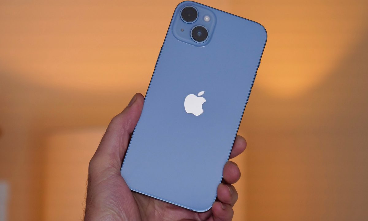 The iPhone 14 Plus held in a man's hand.