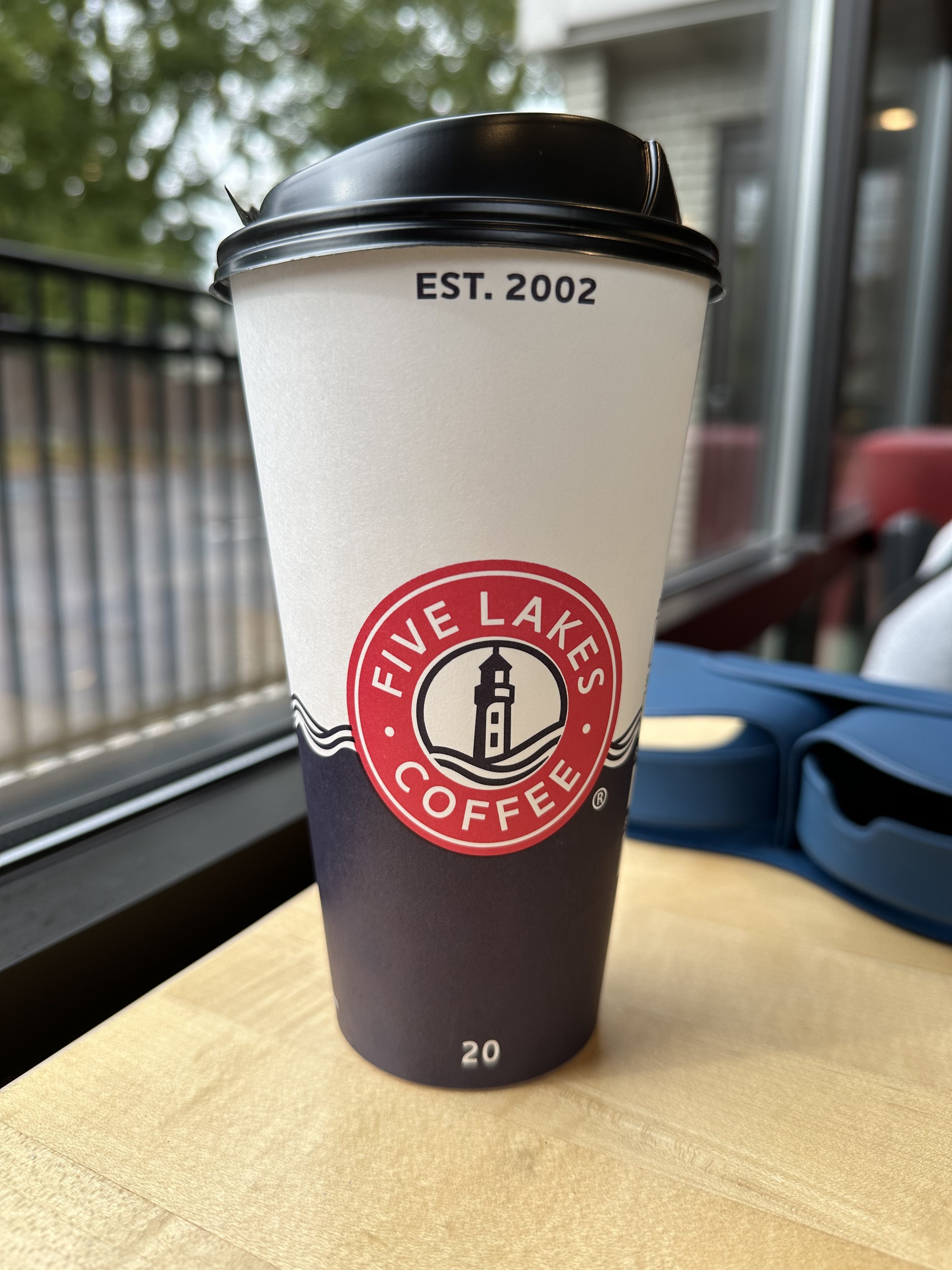 A to-go coffee cup sitting on a table.