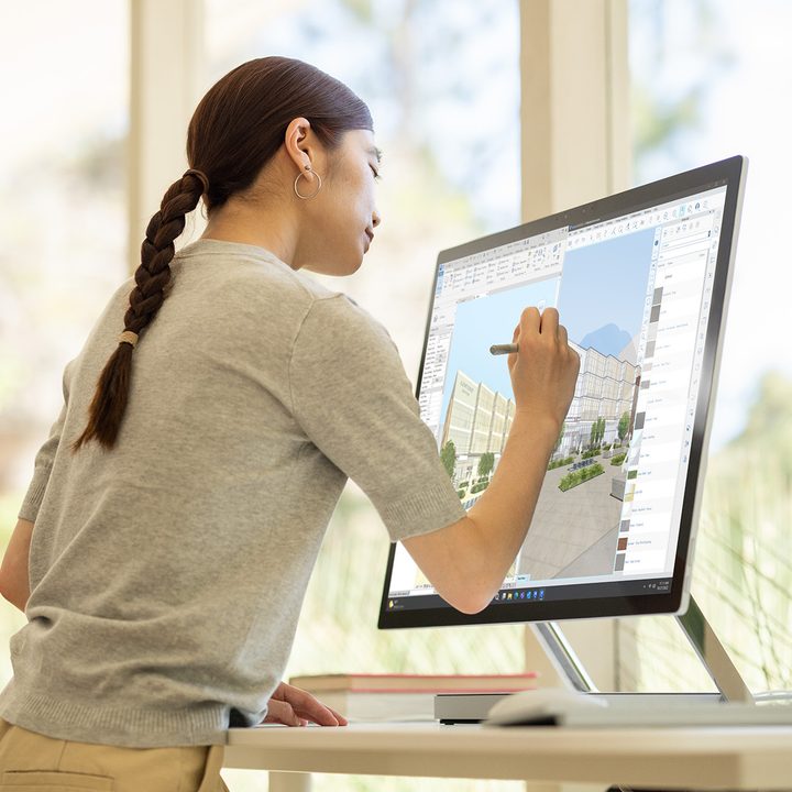 A woman using the Microsoft Surface Studio 2+.