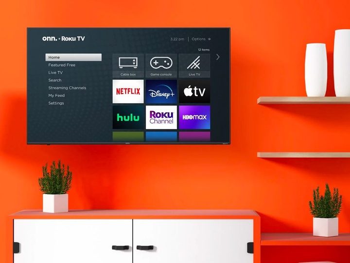 The onn. 70-inch 4K Roku TV hangs on the wall as part of a home theater arrangement.