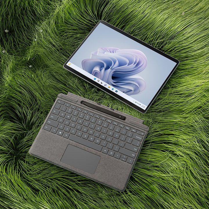 The Surface Pro 9 in grass, separated from the keyboard.