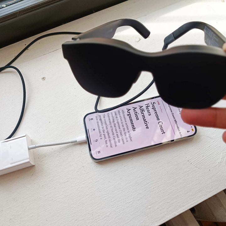 Someone holding a pair of Nreal Air glasses.