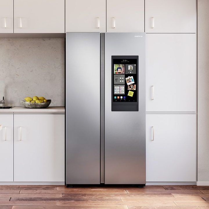 27.3-cubic foot Samsung Smart Side-by-Side Refrigerator with Family Hub in a kitchen with light cabinets and wooden floor.