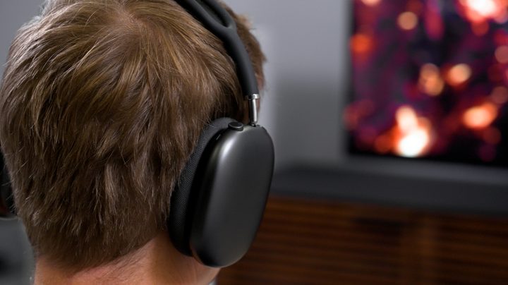 A viewer uses AirPods Max headphones to experience Spatial Audio on the new Apple TV 4K