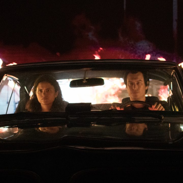 Two vampires sit in the front of a car in a scene from Blood Relatives.
