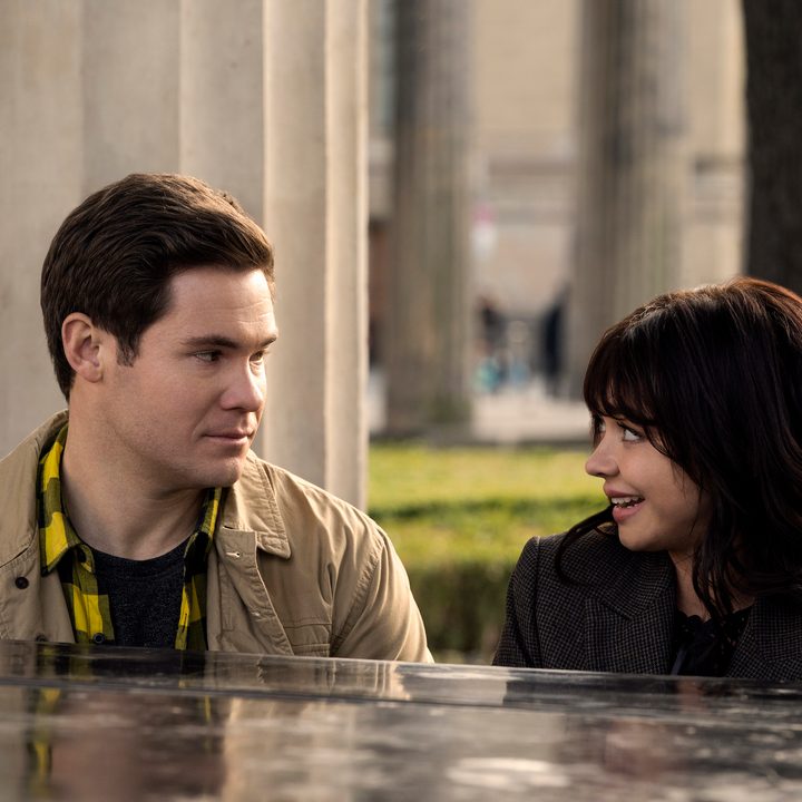Adam Devine and Sarah Hyland sit at a piano in a scene from Pitch Perfect: Bumper in Berlin.