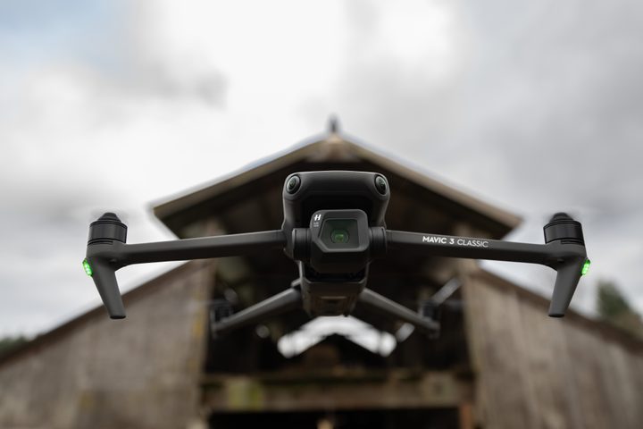 DJI Mavic 3 Classic flying in front of an old barn.