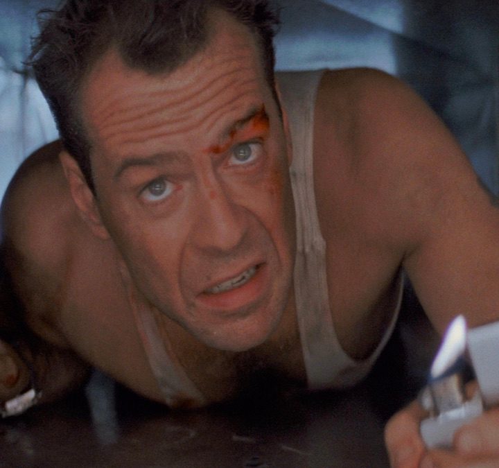 Bruce Willis holds a lighter in a scene from Die Hard.