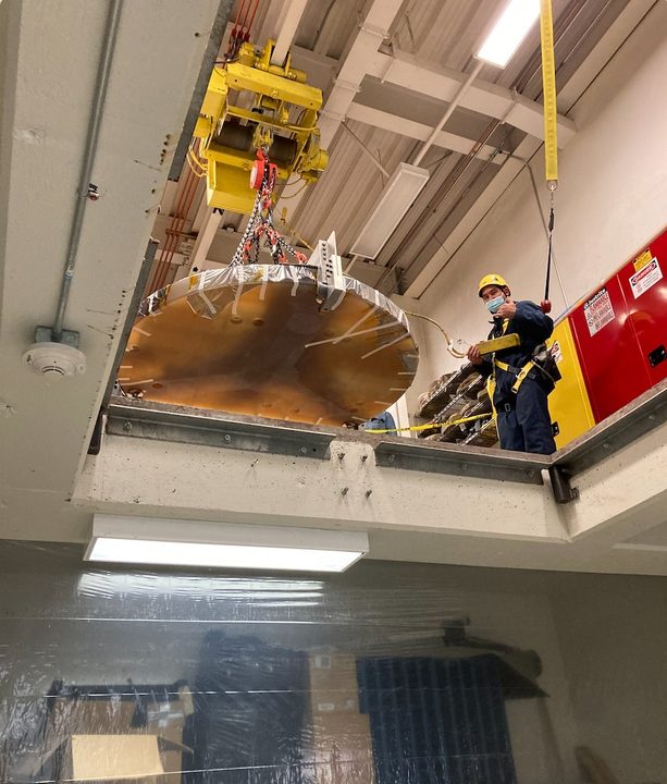 James Chong, infrastructure technician at Keck Observatory, assisting with the delicate lift of the Zerodur optics bench into the observatory basement where the instrument resides.