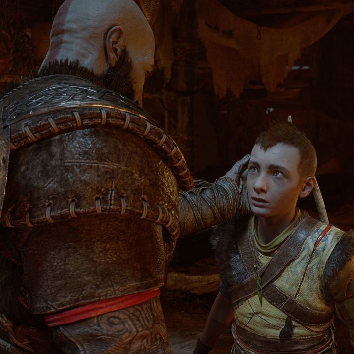 Kratos holds Atreus' face in God of War: Ragnarok.
