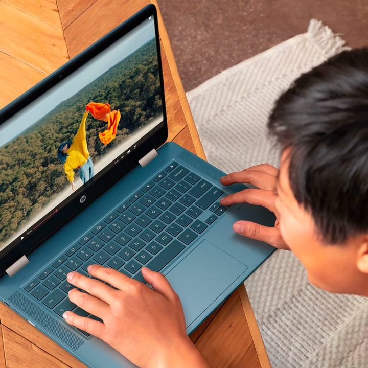 A college-aged student interacts with his HP Chromebook x360.