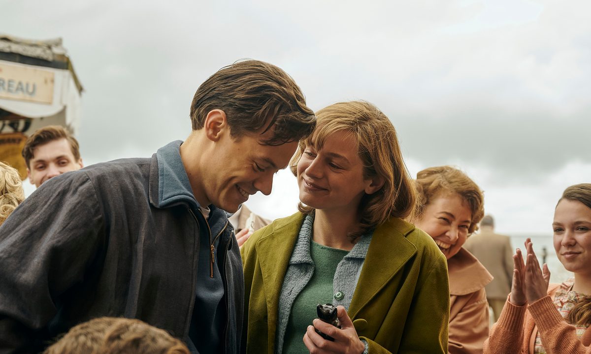 Harry Styles and Emma Corrin stand in a crowd together in My Policeman.