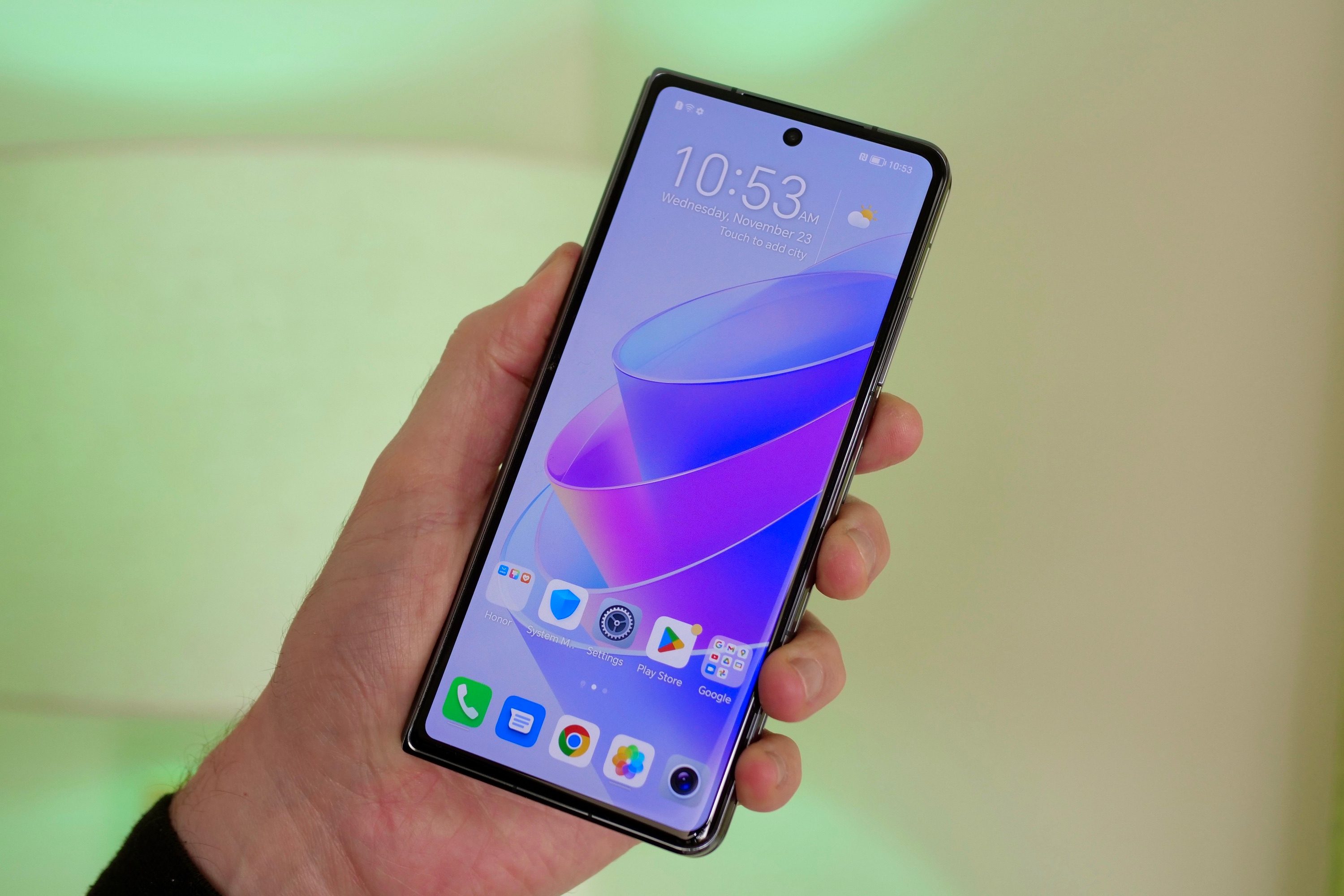 The Honor Magic Vs's cover screen and held in a person's hand.