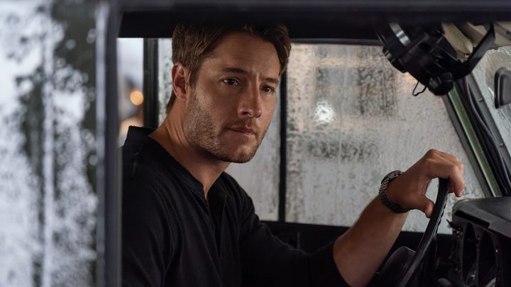 A man puts his hand on the steering wheel in a car in a scene from The Noel Diary.