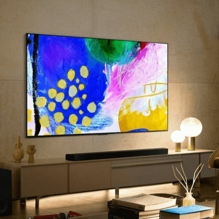 An LG B2 OLED 4K Smart TV attached to a wall above an entertainment center in a living room.