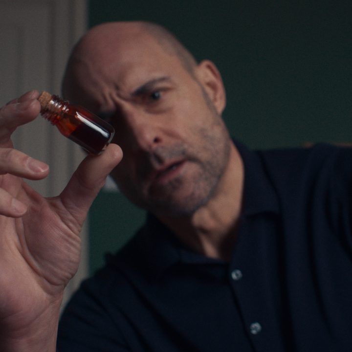 Mark Strong holds a vial of blood in a scene from Nocebo.