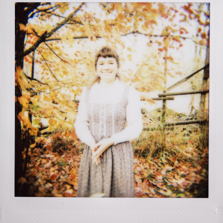 Instax photo of a girl in a dress.
