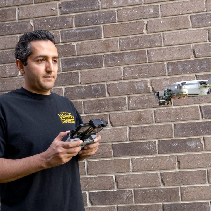 Professor Ali Abedi flying Wi-Peep standing against brick wall.