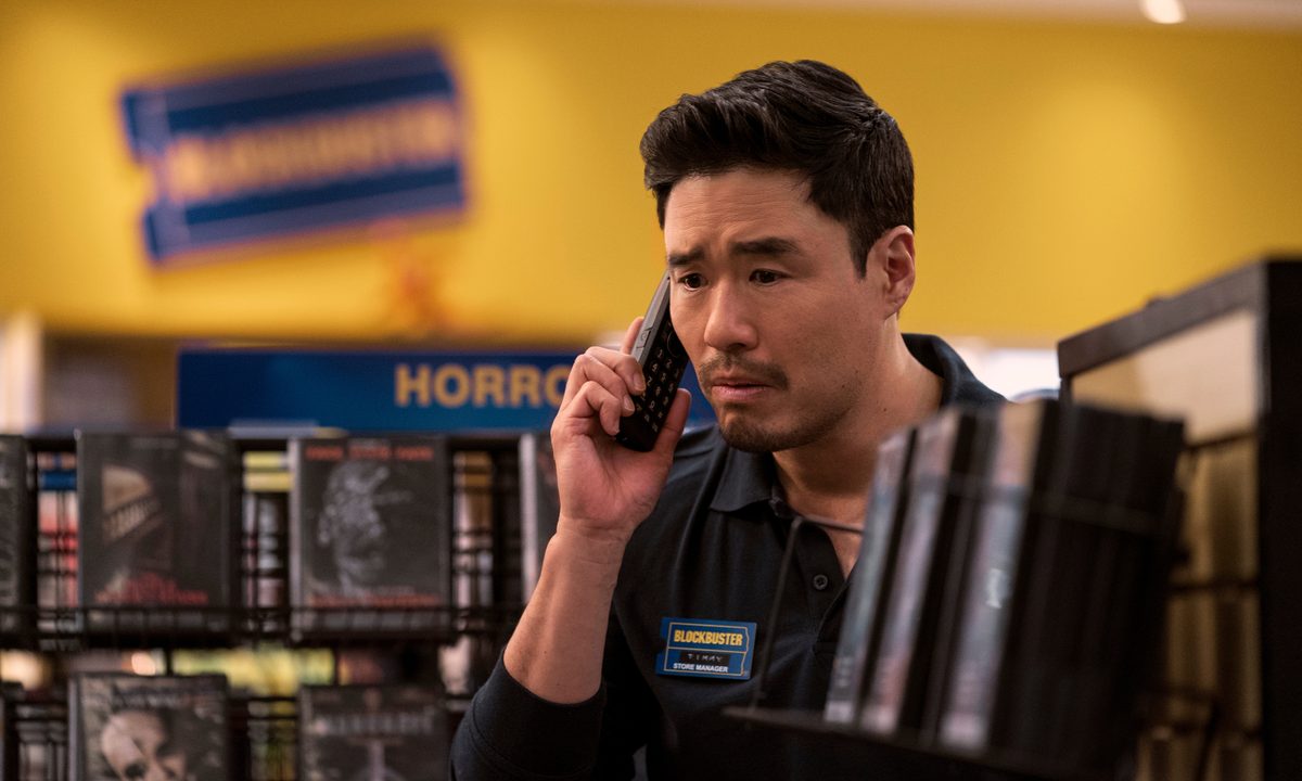 Randall Park holds a phone to his ear in Netflix's Blockbuster.
