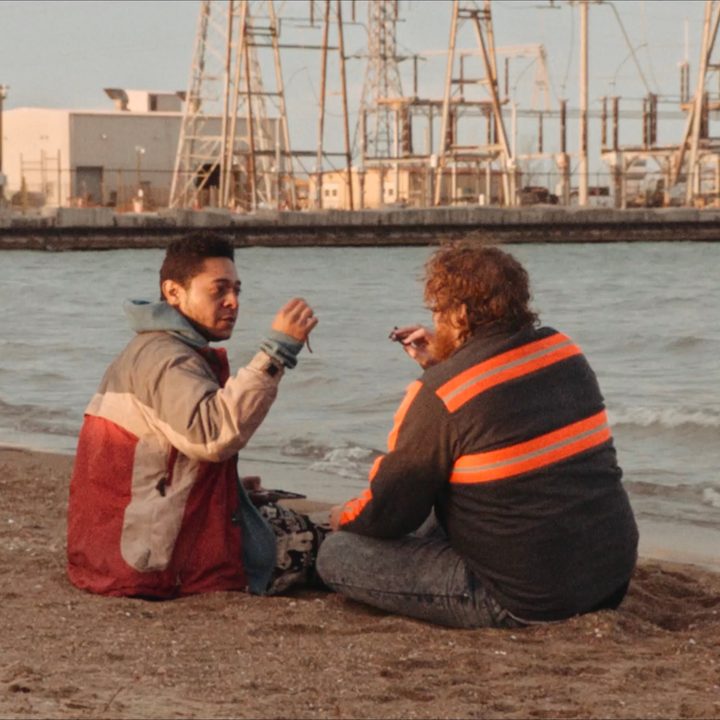 Two men sit down and hold up worms in a scene from All Jacked Up and Full of Worms.