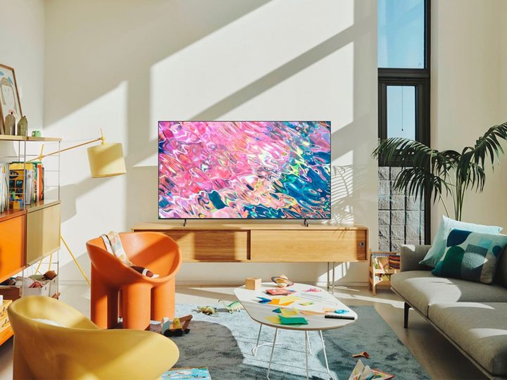 The Samsung Q60B QLED Smart TV sits on a media cabinet in a living room.