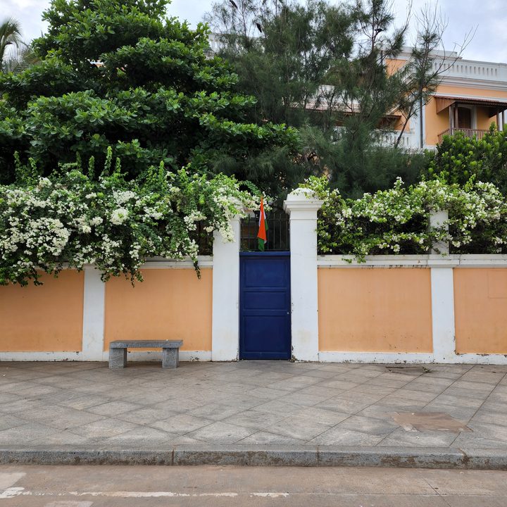 Property with cream walls, blue gate, and Indian flag captured with the Samsung Galaxy S22 Ultra.