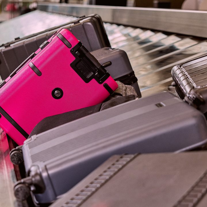 An image of the Un-carrier On standing out among a group of black and grey suitcases.