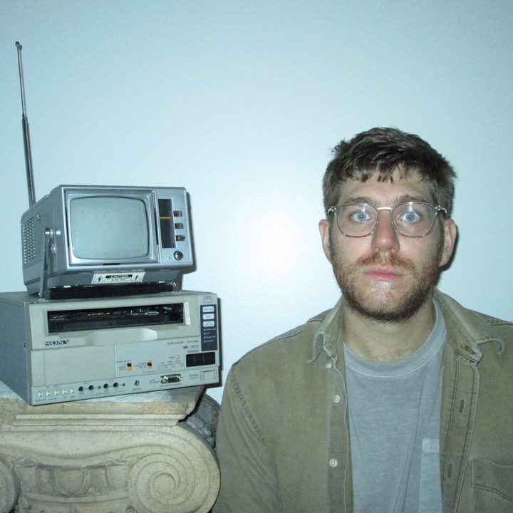 Alex Phillips poses in front of an old television.