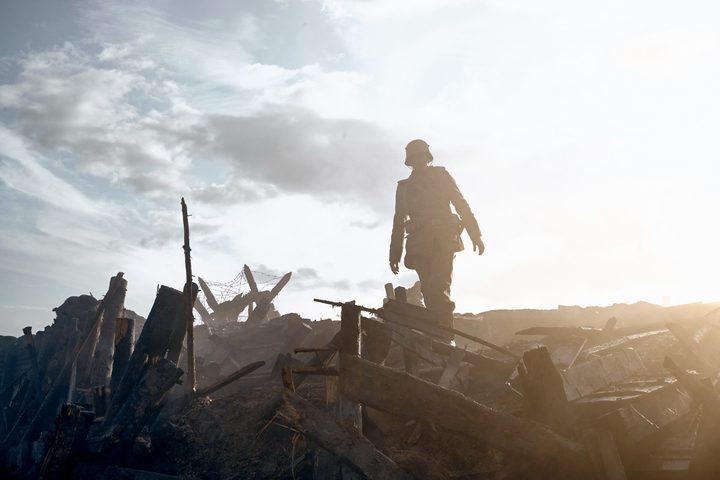 A soldier walks in an empty battlefield in All Quiet on the Western Front.