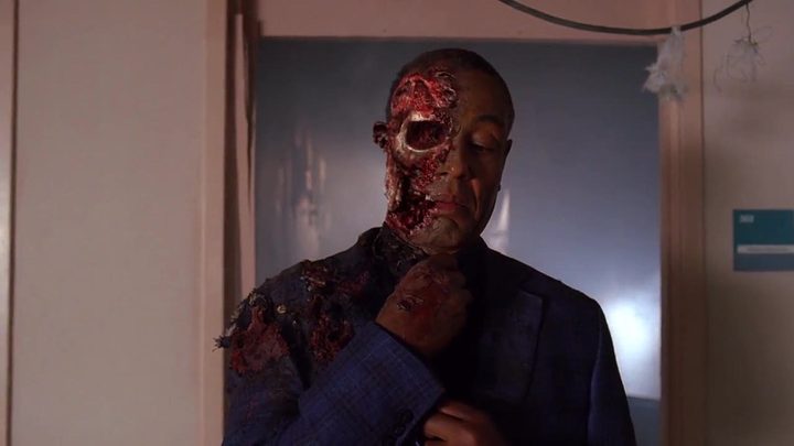 Gus Fring adjusting his tie, half his face blown off in a scene from Breaking Bad.