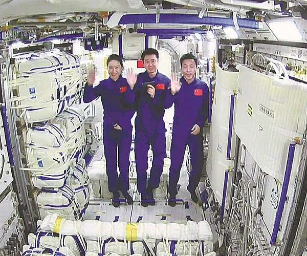 Shenzhou-14 astronauts Chen Dong (C), Liu Yang (L) and Cai Xuzhe waving inside the Mengtian lab module.
