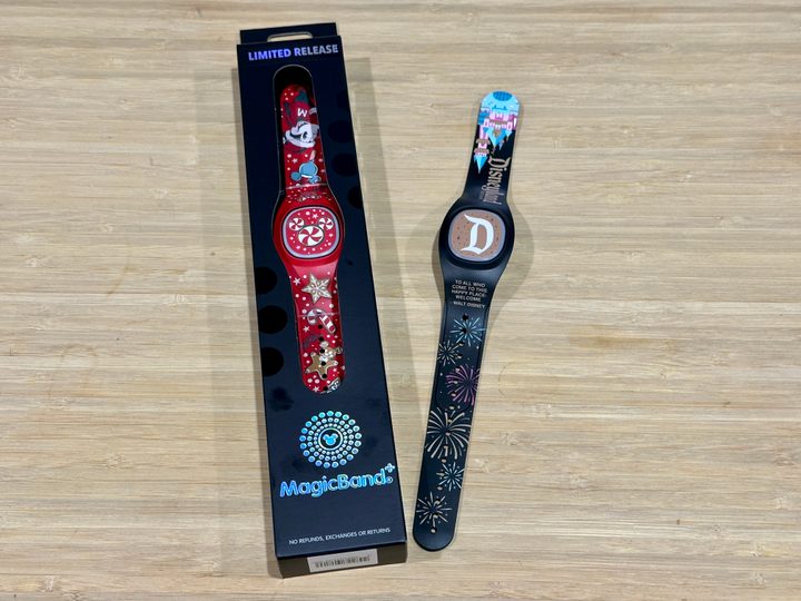 Holiday MagicBand+ in packaging with Disneyland Castle Fireworks band next to it