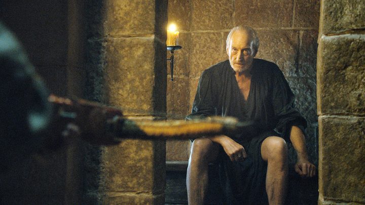 Tywin Lannister on the privy, Tyrion in the foreground in a scene from Game of Thrones.