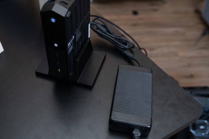 The Intel NUC 12 Enthusiast sitting next to its power brick.