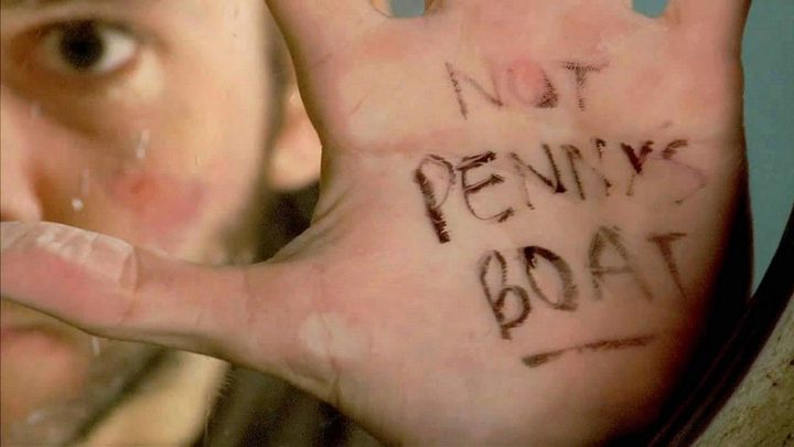 Charlie underwater holding his hand up to glass showing the words "Not Penny's Boat" in a scene from Lost.