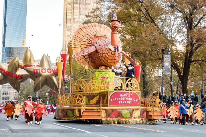 Tom the Turkey floats down the street in a Thanksgiving Day parade.