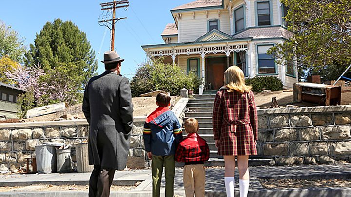 Don Draper standing in front of a house with his kids on Mad Men.