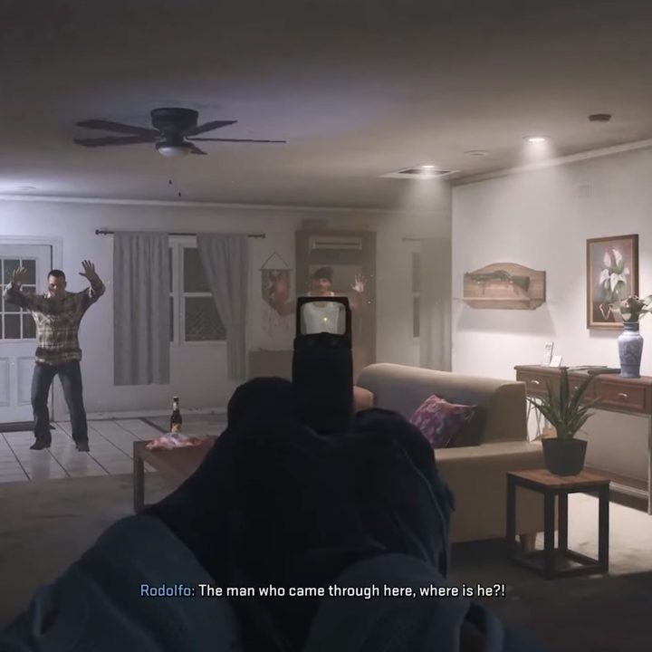An image from Modern Warfare 2 of a gun being pointed at a civilian inside a house from the "Borderline" mission.