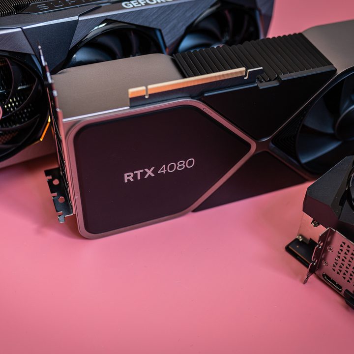 Three RTX 4080 cards sitting on a pink background.
