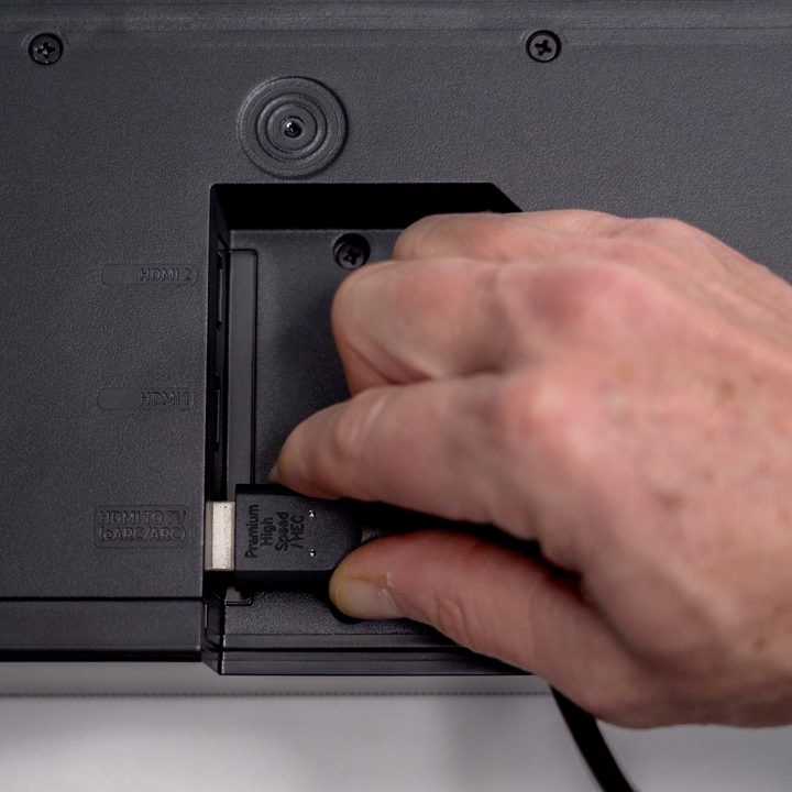Inserting an HDMI cable underneath the Samsung Q990B soundbar