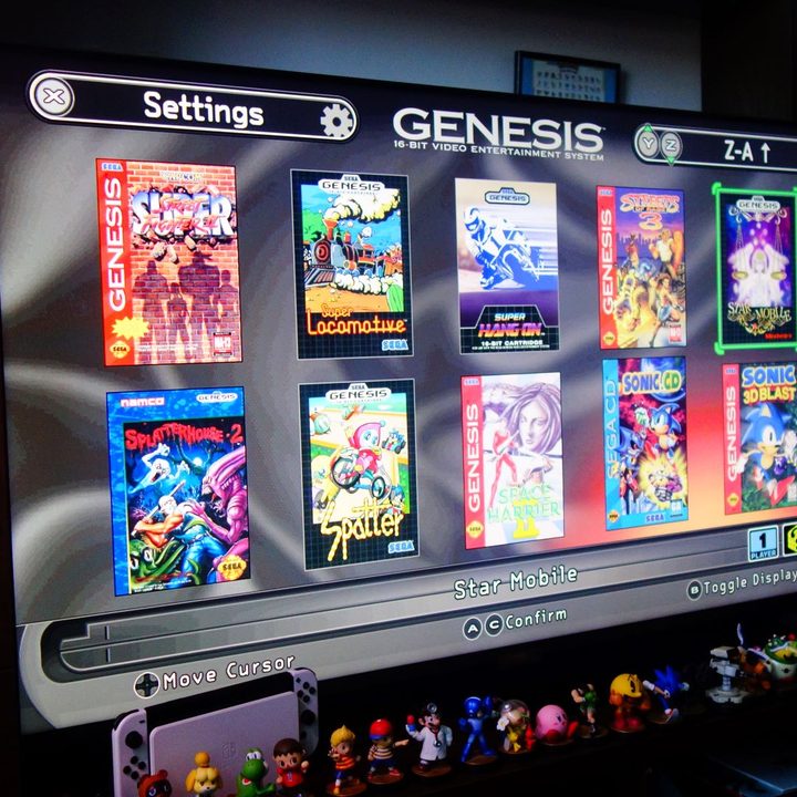 The game selection screen from a Sega Genesis Mini 2 appears on a TV.