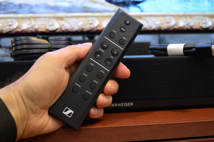 Remote control held in hand: Sennheiser Ambeo Soundbar Plus.