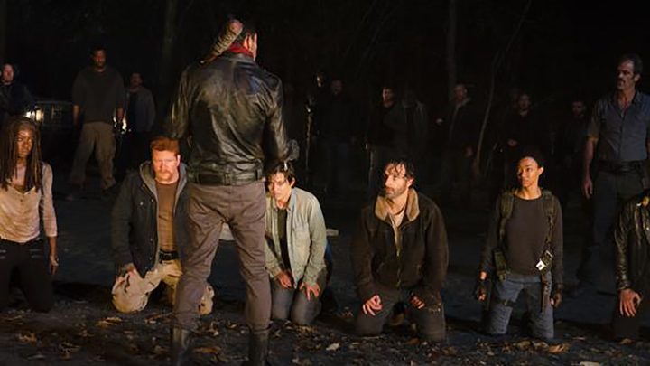 Negan standing in front of Rick and other members of his group holding his bat Lucille on The Walking Dead.