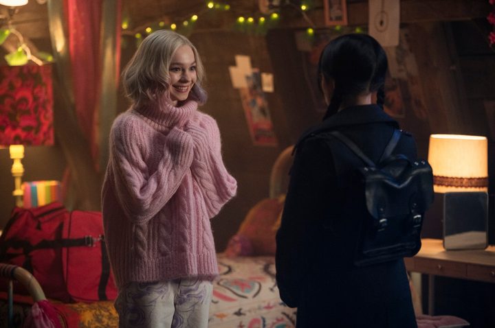 Emma Myers smiles at Jenna Ortega in a scene from Wednesday.